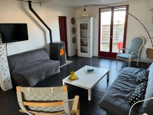 a living room with a couch and a table at Charmante maison landaise in Soustons