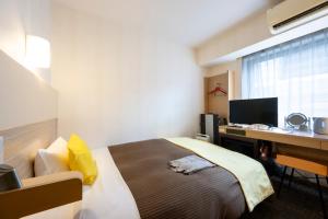 een hotelkamer met een bed en een bureau met een computer bij Hotel 1-2-3 Takasaki in Takasaki