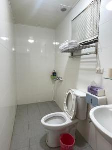 un bagno bianco con un water e un lavandino di 春屏民宿 a Magong