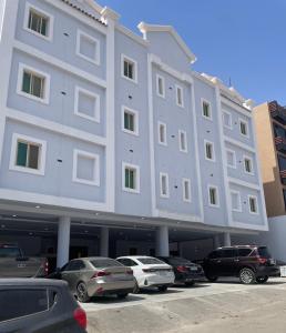 un grande edificio bianco con auto parcheggiate in un parcheggio di الرياض الفندقية Hotel 'AlRiyadh a Riyad
