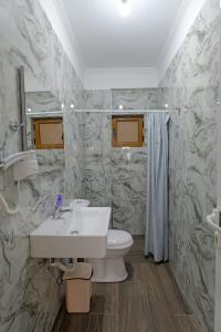 La salle de bains est pourvue d'un lavabo et de toilettes. dans l'établissement Eduard Lagji Apartament, à Lukovë