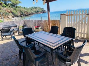a table and chairs on a patio near the ocean at casina mare sulla spiaggia in Capoliveri