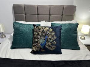 a bed with green and white pillows at Modern, spacious with s/king bed Apartment in Brentwood