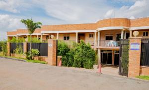 un bâtiment en briques avec une clôture devant lui dans l'établissement IGITEGO APARTHOTEL LTD, à Kigali