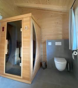 Naturparadies Pressegger See - Nassfeld - Weissensee في هيرماغور: حمام مع مرحاض في كابينة خشبية