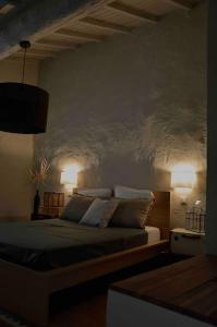 a bedroom with a bed and two lights on the wall at La loge familiale: 110m2, place rose goudard, AC in LʼIsle-sur-la-Sorgue