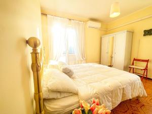 ein Schlafzimmer mit einem Bett und einem Fenster mit Blumen in der Unterkunft residenza nel cuore di Borno. in Borno