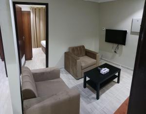 sala de estar con sofá, silla y mesa en ماجيك سويت الرقعى Magic Suite AlRaggi en Kuwait