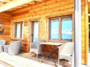 a wooden cabin with a table and chairs on the porch at Le Petit Observatoire in Chardonne