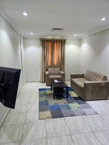 sala de estar con sofá y TV en ماجيك سويت الرقعى Magic Suite AlRaggi en Kuwait