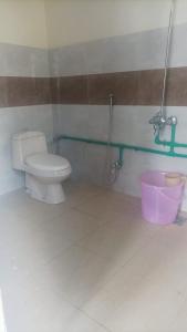 ein Badezimmer mit einem WC und einem rosa Eimer in der Unterkunft Baltistan guest house in Skardu