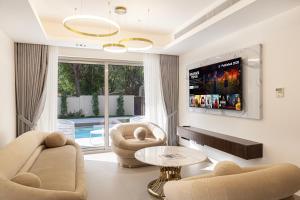 sala de estar con 2 sillas y TV en Luxurious Villa, Private Pool and Garden, Dubai, en Dubái