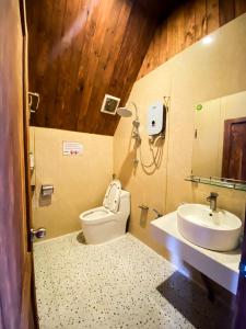 ein Bad mit einem WC und einem Waschbecken in der Unterkunft Vườn Hoa Măng Đen Village in Kon Plong