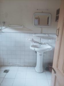 ein Badezimmer mit einem weißen Waschbecken und einem Spiegel in der Unterkunft Baltistan guest house in Skardu