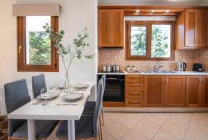 a kitchen with a white table with chairs and a sink at Katrin Aegina in Egina +17 photos