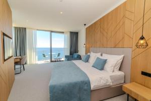ein Hotelzimmer mit einem Bett und Meerblick in der Unterkunft Hotel & Spa Ponta Plaza in Budva
