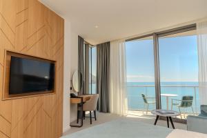 a hotel room with a television and a view of the ocean at Hotel & Spa Ponta Plaza in Budva