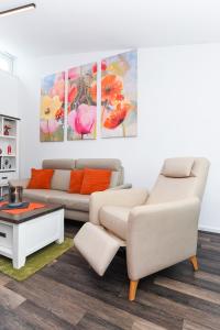 ein Wohnzimmer mit einem Sofa und einem Tisch in der Unterkunft Ferienhaus Krosse Krabbe in Bensersiel
