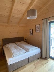 een slaapkamer met een bed in een houten kamer bij Wohlfühlchalet Hermagor-Nassfeld-Weissensee in Hermagor