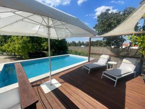 una piscina con due sedie e un ombrellone di Monte Velho - Country House a Canha Altre 16 foto