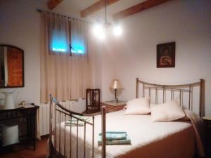 um quarto com uma cama com lençóis brancos e uma janela em Casa Rural Marques de Cerralbo em Santa María de Huerta