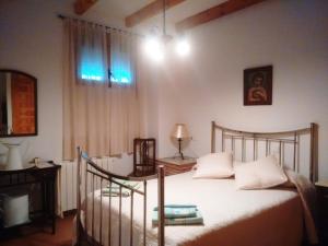 una camera da letto con un letto con lenzuola bianche e una finestra di Casa Rural Marques de Cerralbo a Santa María de Huerta Altre 4 foto