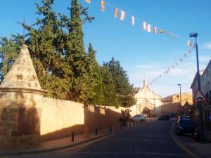 a street with a wall with flags and a building at Casa Rural Marques de Cerralbo in Santa María de Huerta