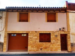 una casa con dos puertas de garaje y dos ventanas en Casa Rural Marques de Cerralbo, en Santa María de Huerta