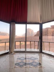 a room with large windows with a view of the desert at joy of life in Wadi Rum