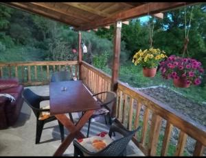a wooden deck with a table and chairs on a porch at Planinska kuca in Rap