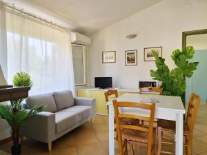 a living room with a couch and a table at Villa Scogliera - Appartamenti con veranda a circa 700 mt dalla spiaggia di Fuile e Mare in Cala Liberotto