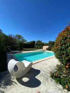 a swimming pool with a white chair next to it at LeCalleBed-Breakfast in Chia