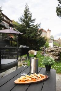 eine Käseplatte und ein Glas Wein auf dem Tisch in der Unterkunft Le Saint Georges in Gruyères