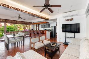 - un salon avec un canapé et une télévision dans l'établissement Beachfront Villa, Bang Po, à Ban Bang Po