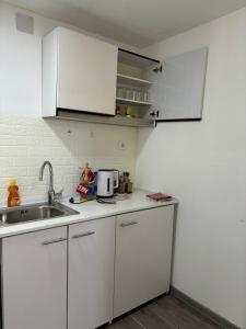 a kitchen with white cabinets and a sink at Visoko Piramide II in Visoko