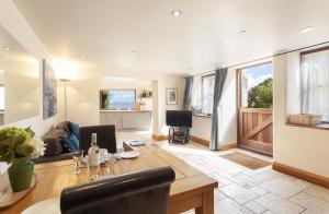 a living room with a table and a dining room at The Coach House in Porlock