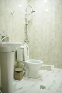 ein Badezimmer mit einem weißen WC und einem Waschbecken in der Unterkunft Square Inn in Gjumri
