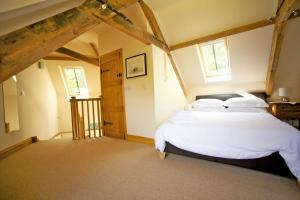 1 dormitorio con 1 cama con sábanas y almohadas blancas en The Coach House, en Porlock