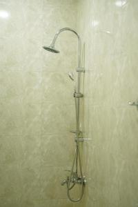 een douche met een douchekop in de badkamer bij Square Inn in Gjoemri