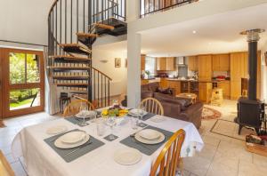 uma sala de jantar com uma mesa e uma escada em espiral em Harthanger View Cottage, Luxborough em Luxborough