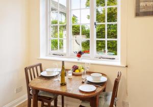 a dining room table with two chairs and a window at Coachman's Cottage, West Porlock in Porlock +21 photos