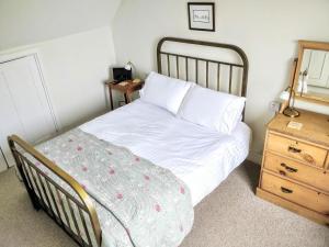 ポーロックにあるCoachman's Cottage, West Porlockのベッドルーム(白いベッド1台、木製のナイトスタンド付)