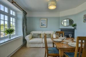 a living room with a table and a couch at Coach House in Washford