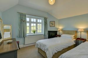 a bedroom with two beds and a window at Coach House in Washford