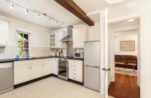 an open kitchen with white cabinets and appliances at Luccombe Cottage in Luccombe in Luccombe