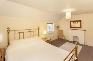 a bedroom with a bed and a fireplace at Worthy Cottage in Porlock