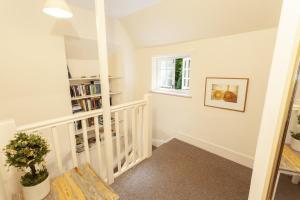 a white staircase with a window and a book shelf at Worthy Cottage in Porlock