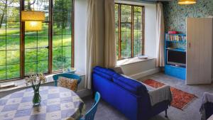 a living room with a blue couch and a table at Barn Cottage, Brayford in Charles