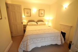 een slaapkamer met een bed met een wit dekbed bij Hurlestone Apartment in Porlock