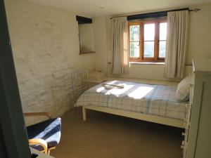 West Huckham Barn في دولفيرتون: غرفة نوم صغيرة بها سرير ونافذة